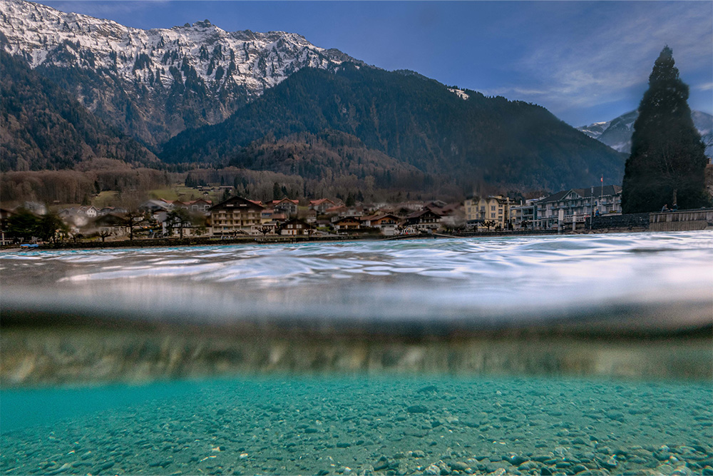 Kamera leicht ins klare Wasser gehalten Blick vom See auf Interlaken